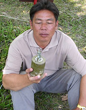 Lim holding a landmine - part of the WRF and McMahan AA efforts to clean up Cambodia